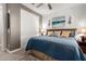 Cozy bedroom features a blue quilt, decorative pillows, and a closet with white sliding doors for ample storage at 16906 W Palm Ln, Goodyear, AZ 85395