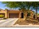 Charming single-story home with tile roof, arched entryway, and well-maintained desert landscaping at 16906 W Palm Ln, Goodyear, AZ 85395