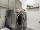 Laundry room featuring modern washer and dryer, storage cabinets, and convenient functionality at 16906 W Palm Ln, Goodyear, AZ 85395