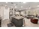Open floor plan featuring kitchen island, living room with leather sofa, and bright windows at 16906 W Palm Ln, Goodyear, AZ 85395