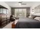 Comfortable main bedroom boasts soft carpet, a ceiling fan, and bright windows with plantation shutters at 16906 W Palm Ln, Goodyear, AZ 85395
