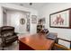Inviting office boasts natural light and a warm wood desk with a laptop on the surface at 16906 W Palm Ln, Goodyear, AZ 85395