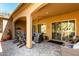 Inviting covered patio with comfortable seating, stylish decor, and a ceiling fan for a relaxing outdoor experience at 16906 W Palm Ln, Goodyear, AZ 85395