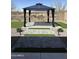 This landscaped backyard features a gazebo, artificial turf, and a decorative gravel border at 1702 N 214Th Ln, Buckeye, AZ 85396