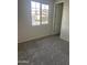 Carpeted bedroom with window view and neutral paint at 1702 N 214Th Ln, Buckeye, AZ 85396
