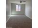 A carpeted bedroom with a ceiling fan and bright window at 1702 N 214Th Ln, Buckeye, AZ 85396