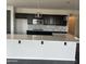 Modern kitchen with sleek dark cabinetry, stainless steel appliances and a white countertop island at 1702 N 214Th Ln, Buckeye, AZ 85396