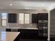 Charming kitchen with dark cabinets, stainless appliances, designer backsplash and bright natural light at 1702 N 214Th Ln, Buckeye, AZ 85396