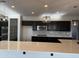 Modern kitchen with sleek dark cabinetry, stainless steel appliances and a white countertop island at 1702 N 214Th Ln, Buckeye, AZ 85396
