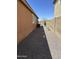 View of the side yard featuring gravel, block wall fence, and glimpses of distant mountains at 1702 N 214Th Ln, Buckeye, AZ 85396