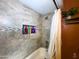 Tiled shower with shampoo niche in a bathroom with a granite countertop vanity and hanging plant at 1720 E Intrepid Ave, Mesa, AZ 85204