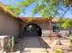 A charming single-story home with a unique stone archway leading to the front entrance at 1720 E Intrepid Ave, Mesa, AZ 85204