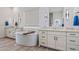 Bright bathroom with double vanity, tile floors, and soaking tub at 17396 W Crawfordsville Dr, Surprise, AZ 85388