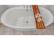 Close up of soaking tub with wood serving tray and bath accessories at 17396 W Crawfordsville Dr, Surprise, AZ 85388