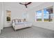 Bright bedroom with plenty of natural light, modern ceiling fan, and nice patterned floors at 17396 W Crawfordsville Dr, Surprise, AZ 85388