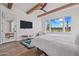 Bright bedroom with wood beams, wood floors, area rug, and patio view at 17396 W Crawfordsville Dr, Surprise, AZ 85388