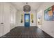 Bright foyer featuring a decorative blue door, tile flooring and chandelier at 17396 W Crawfordsville Dr, Surprise, AZ 85388