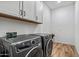 Convenient laundry room equipped with modern washer and dryer, plus lots of cabinet space at 17396 W Crawfordsville Dr, Surprise, AZ 85388