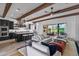 Open-concept living room with wooden beams, leading to a patio with outdoor seating at 17396 W Crawfordsville Dr, Surprise, AZ 85388