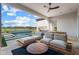 Relaxing outdoor patio featuring stylish seating, a ceiling fan, and views of the pool and lush backyard at 17396 W Crawfordsville Dr, Surprise, AZ 85388