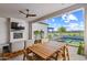 Inviting outdoor patio with fireplace, TV, dining table, and a beautiful view of the pool and backyard at 17396 W Crawfordsville Dr, Surprise, AZ 85388