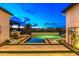 A luxurious backyard boasts a modern pool design, a built-in grill, and is perfect for outdoor entertaining and relaxation at 17396 W Crawfordsville Dr, Surprise, AZ 85388