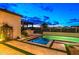A stunning backyard featuring a modern pool, a built-in grill, and lush landscaping, creating an ideal outdoor oasis at 17396 W Crawfordsville Dr, Surprise, AZ 85388