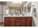Bathroom vanity with dual sinks, custom cabinets, and a large mirror at 17517 W Dahlia Dr, Surprise, AZ 85388