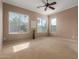 Bright bedroom with multiple windows, carpeted floors, and ceiling fan at 17517 W Dahlia Dr, Surprise, AZ 85388