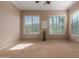Spacious carpeted bedroom features large windows offering plenty of natural light at 17517 W Dahlia Dr, Surprise, AZ 85388