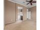 Carpeted primary bedroom showing bathroom entrance and neutral paint at 17517 W Dahlia Dr, Surprise, AZ 85388