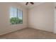 Bedroom with a ceiling fan and view of the backyard at 17517 W Dahlia Dr, Surprise, AZ 85388
