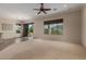 Bright living room with carpet flooring, ceiling fan, and access to the backyard at 17517 W Dahlia Dr, Surprise, AZ 85388