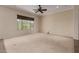 Spacious living room featuring carpet flooring, a ceiling fan, and a large window at 17517 W Dahlia Dr, Surprise, AZ 85388