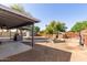 Large backyard featuring a covered patio, planting beds, and a fenced perimeter for privacy at 20816 E Duncan St, Queen Creek, AZ 85142