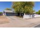 Charming single-story home featuring a well-maintained yard, mature trees and a classic white picket fence at 20816 E Duncan St, Queen Creek, AZ 85142