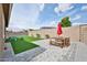 Open backyard featuring artificial grass, a patio set, and block wall, perfect for outdoor entertaining at 23871 N 167Th Ln, Surprise, AZ 85387