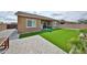Large backyard featuring artificial grass, covered patio, and a paved area, perfect for outdoor living at 23871 N 167Th Ln, Surprise, AZ 85387
