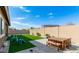 This backyard features an artificial lawn, patio, and a dining set, perfect for outdoor entertaining at 23871 N 167Th Ln, Surprise, AZ 85387