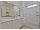 Modern bathroom with a glass-enclosed shower, white cabinets, and a large vanity mirror at 23871 N 167Th Ln, Surprise, AZ 85387