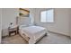 Neutral bedroom features carpet flooring, a large window, and a cozy bed with side tables and lamps at 23871 N 167Th Ln, Surprise, AZ 85387