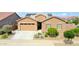 Welcoming home with a lush, green lawn, desert landscaping, and a spacious driveway at 23871 N 167Th Ln, Surprise, AZ 85387