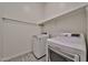 Convenient laundry room with modern, full-size washer and dryer units and overhead shelving at 23871 N 167Th Ln, Surprise, AZ 85387