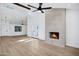 Spacious open floor plan with hardwood floors, a cozy fireplace and modern ceiling fan at 250 E Barbarita Ave, Gilbert, AZ 85234