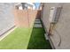 Private backyard space featuring artificial grass, pavers, and convenient utilities for a low-maintenance outdoor area at 25202 N 142Nd Dr, Surprise, AZ 85387