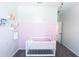 Adorable Bedroom with a pink accent wall, crib, and shelving for books and toys at 25202 N 142Nd Dr, Surprise, AZ 85387