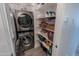 Convenient laundry closet featuring a stackable washer and dryer with shelving for storage at 25202 N 142Nd Dr, Surprise, AZ 85387