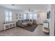 Living room with gray sectional, plantation shutters, and wood-look tile flooring at 25202 N 142Nd Dr, Surprise, AZ 85387