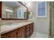 Bathroom with double sinks, granite countertops, framed mirror, and elegant lighting fixtures at 269 E Horseshoe Dr, Chandler, AZ 85249