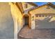 Close up of front entrance featuring desert landscaping, neutral stucco, two car garage and a paver driveway at 269 E Horseshoe Dr, Chandler, AZ 85249